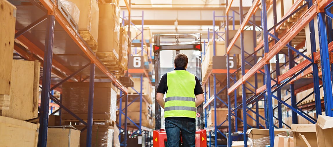 man using lift in warehouse